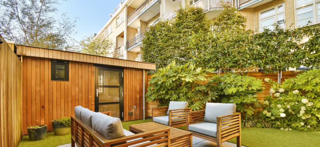 a-backyard-patio-with-wooden-furniture-and-a-lawn